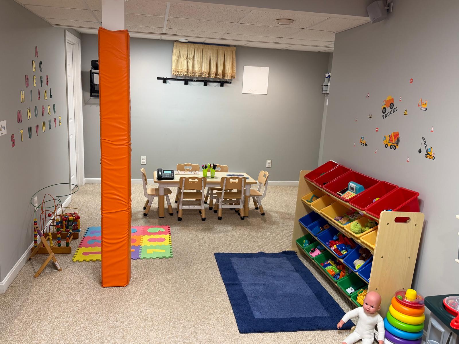 Colorful toy storage bins full of toys, a play kitchen, and stacking toys