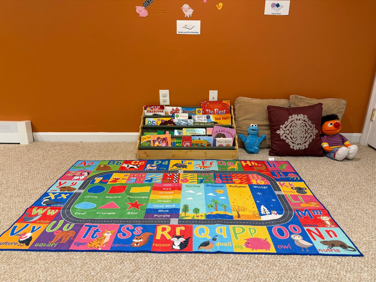 A full view of the playroom showing the activity table, toy storage, play mats, and learning areas